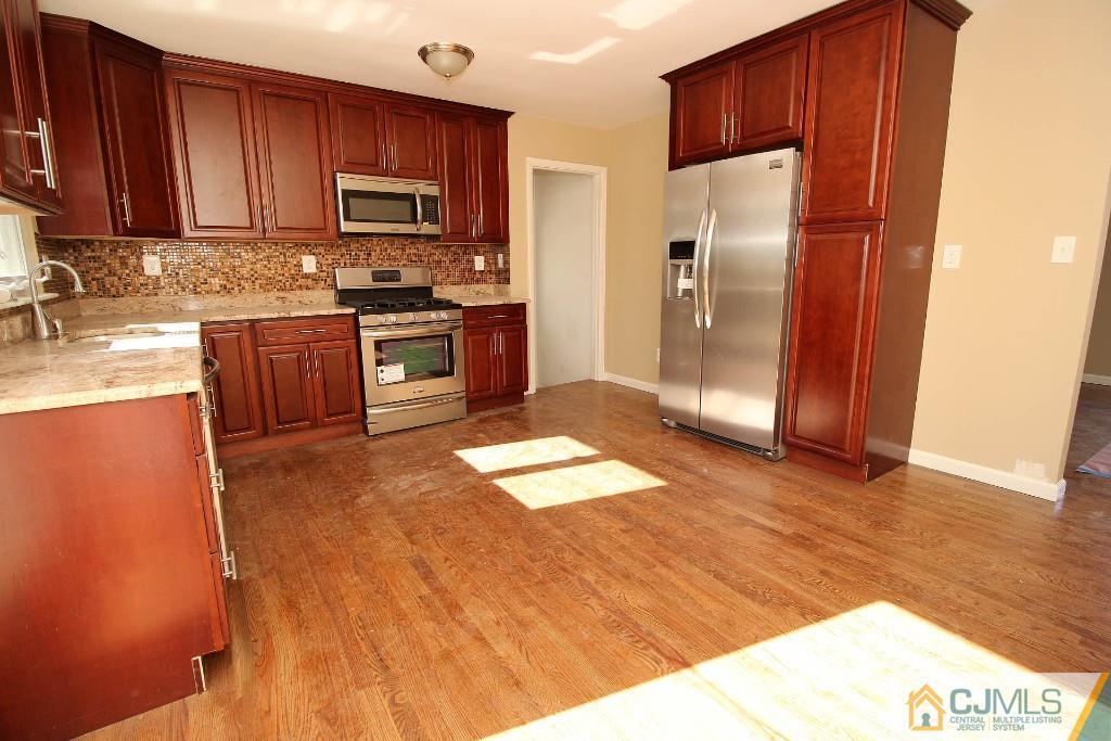 17 Brookside Road Edison, NJ 08817 - Photo 12 of 20 a kitchen with granite countertop stainless steel appliances a stove a sink and a refrigerator