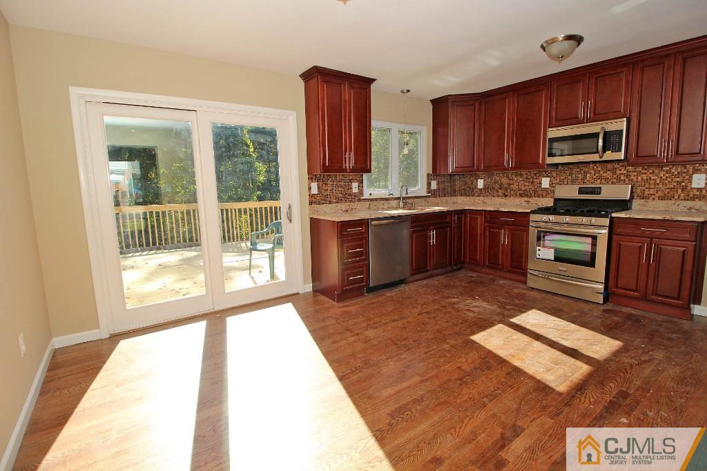 17 Brookside Road Edison, NJ 08817 - Photo 9 of 20 a large kitchen with wooden floors and stainless steel appliances