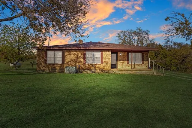 a front view of house with yard and green space