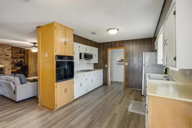 a kitchen with a refrigerator sink and cabinets