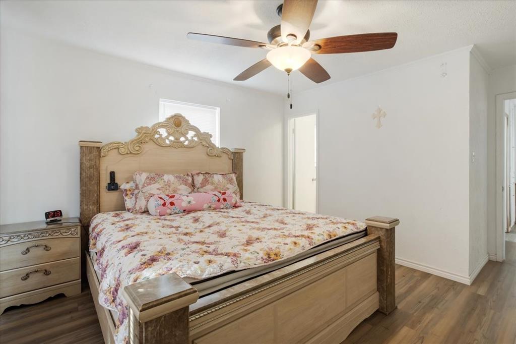 567 Celtic Road Howe, TX 75459 - Photo 21 of 40 a bedroom with a bed and a chandelier