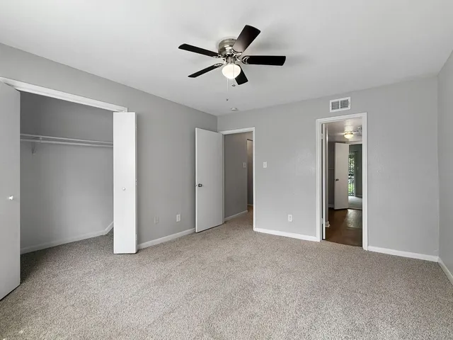 a view of an empty room with a ceiling fan