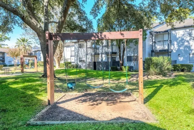a view of a house with backyard and a tree