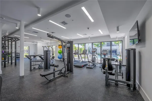 a view of a room with lots of furniture and windows