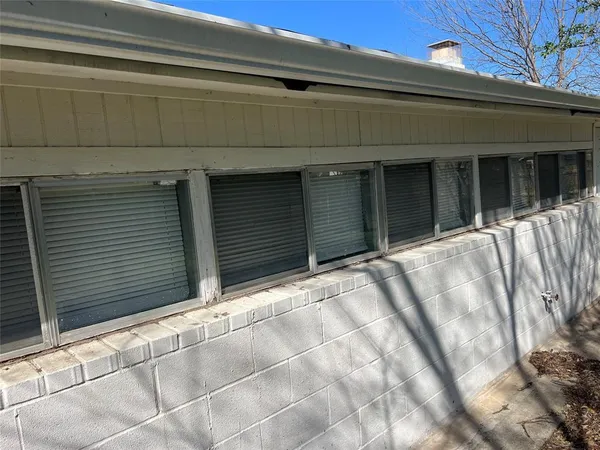 a view of backyard with wooden fence and large trees