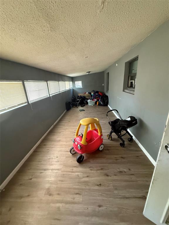 6036 Harrison Way Watauga, TX 76148 - Photo 32 of 39 Playroom with light wood finished floors and a textured ceiling