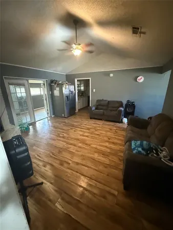 a large bedroom with a bed and wooden floor