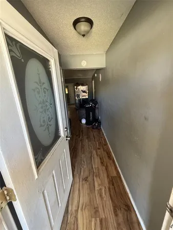a view of a hallway with wooden floor and staircase