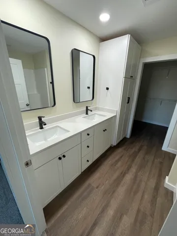 a bathroom with double vanity sink and a mirror