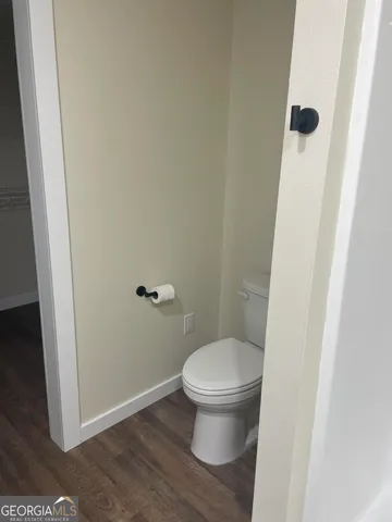 a white toilet sitting next to a shower