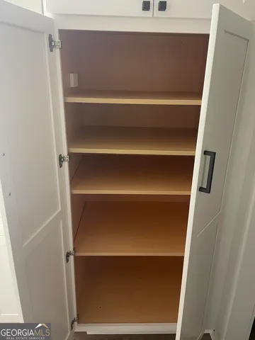 a view of walk in closet with empty racks