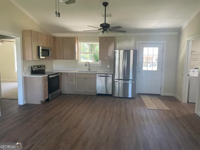 a kitchen with stainless steel appliances granite countertop a hardwood floor sink stove and granite counter top