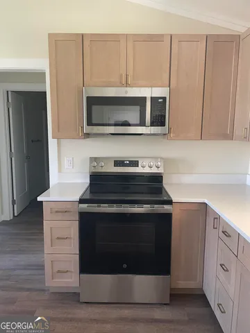a kitchen with stainless steel appliances granite countertop a stove and a microwave
