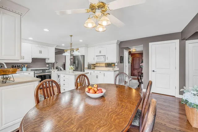 a dining room with stainless steel appliances granite countertop a dining table and chairs