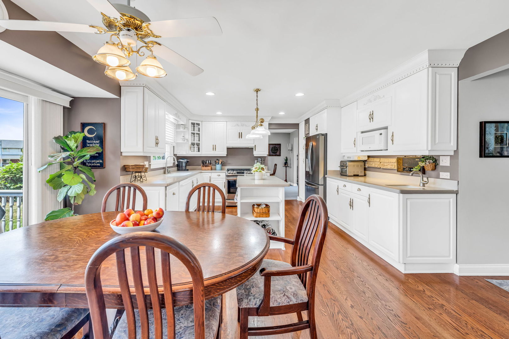 15624 Sunset Ridge Drive Orland Park, IL 60462 - Photo 14 of 37 a kitchen with stainless steel appliances granite countertop a dining table chairs stove a refrigerator and a dining table with wooden floor