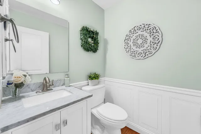a bathroom with a toilet sink and mirror