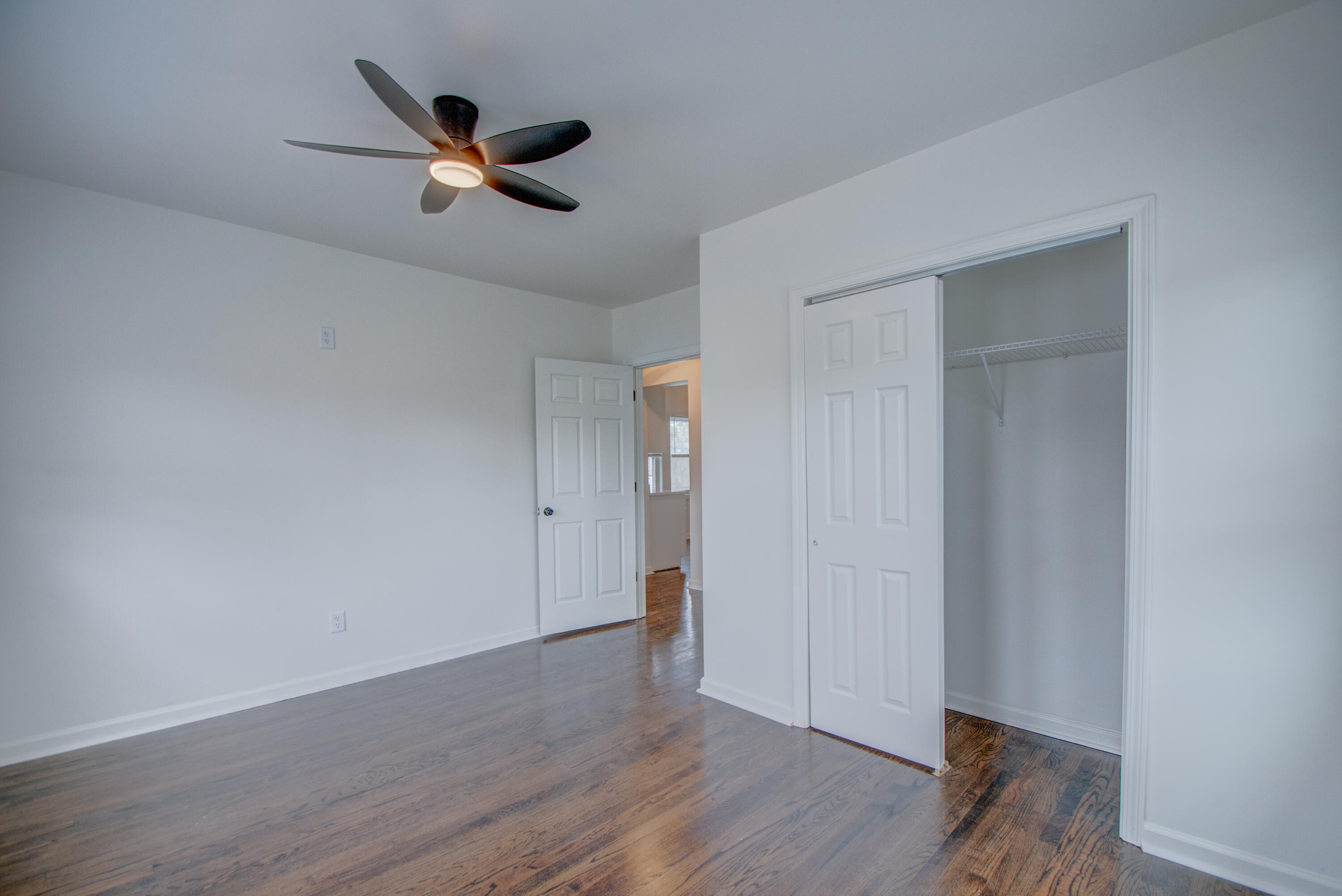 613 Tennessee Street Gary, IN 46402 - Photo 6 of 39 an empty room with wooden floor and a ceiling fan