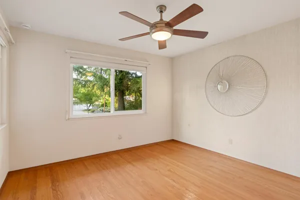 an empty room with a window and a fan