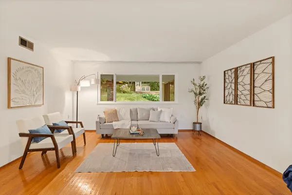 a living room with furniture and a wooden floor