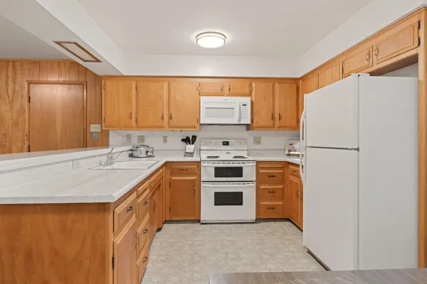 a kitchen with stainless steel appliances granite countertop a refrigerator sink and stove
