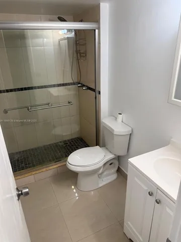 a bathroom with a granite countertop sink a toilet and shower