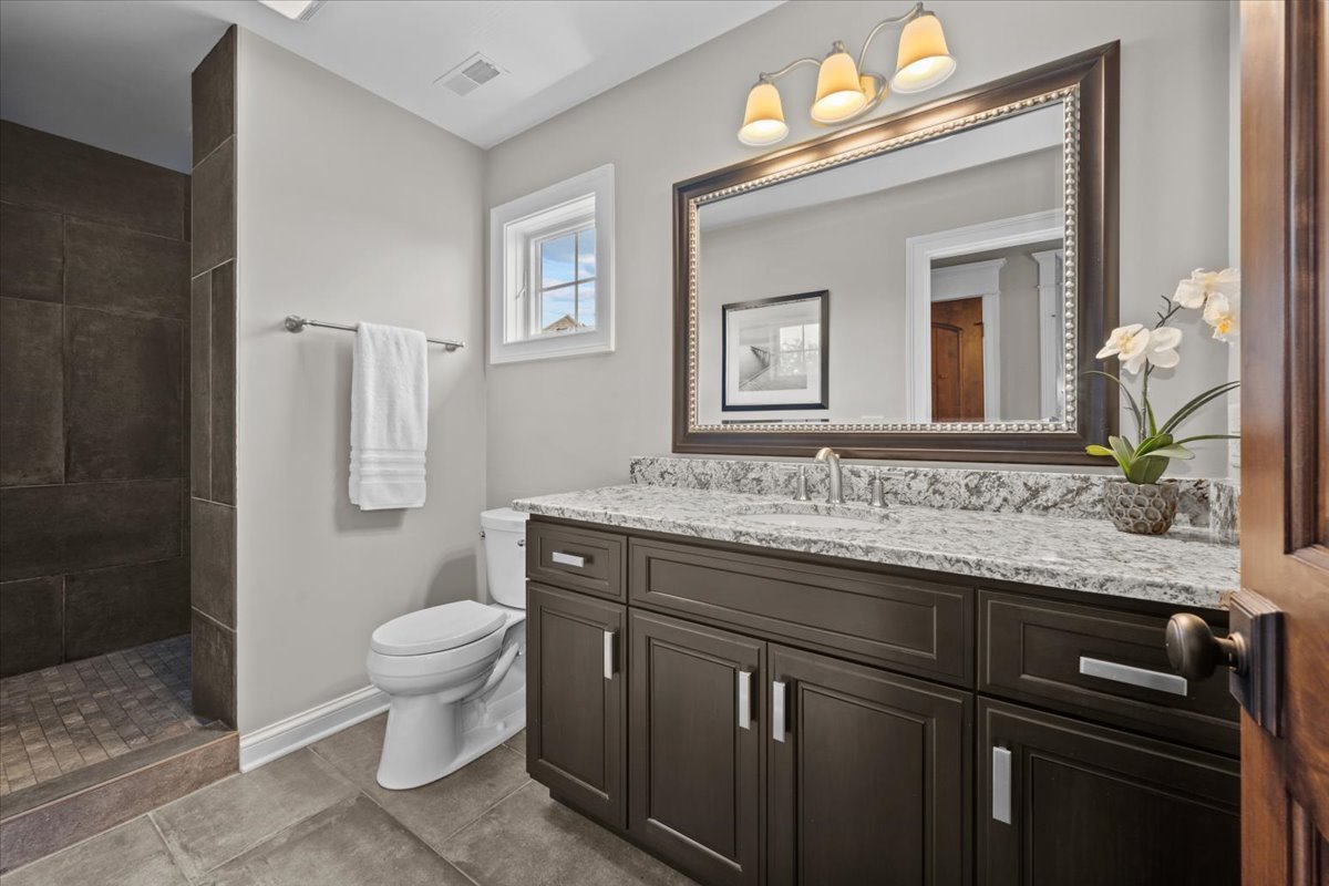 754 Wild Ginger Road Sugar Grove, IL 60554 - Photo 40 of 52 a bathroom with a granite countertop sink a toilet and a mirror