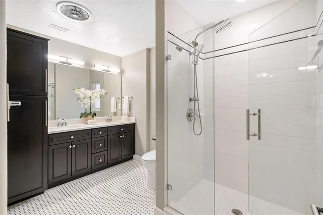 a bathroom with a double vanity sink shower and a mirror