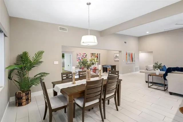 a dining room with furniture potted plants and a chandelier