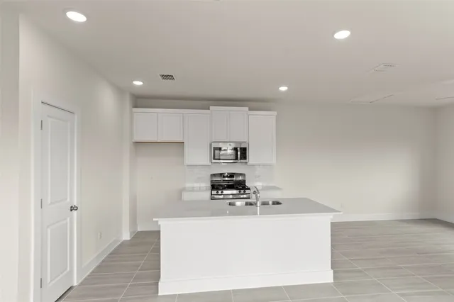 a kitchen with a sink a stove and cabinets