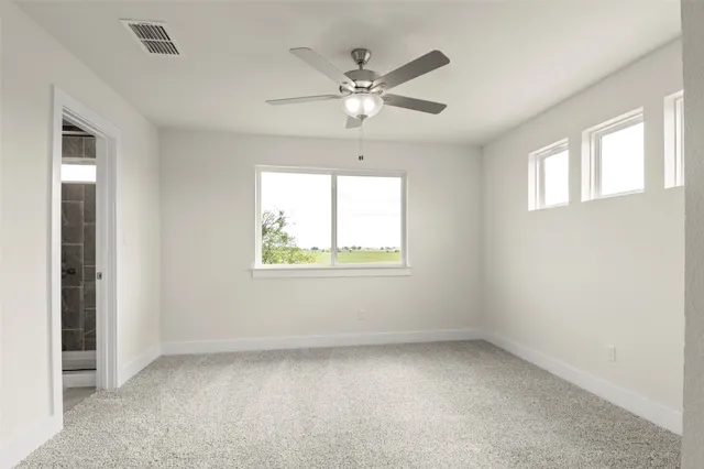 an empty room with windows and fan
