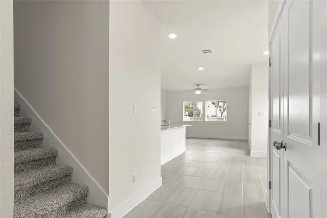 an empty room with a window and a ceiling fan