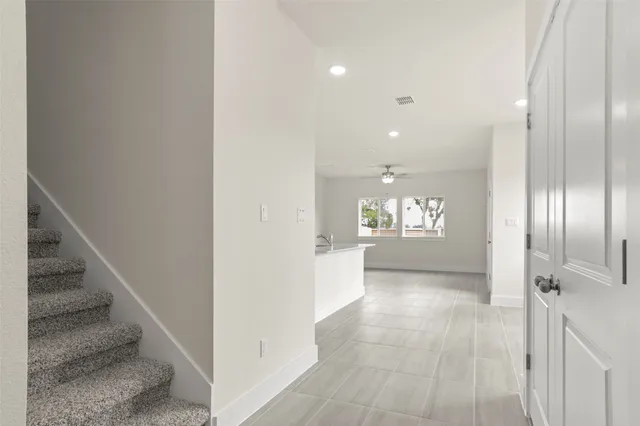 an empty room with a window and a ceiling fan