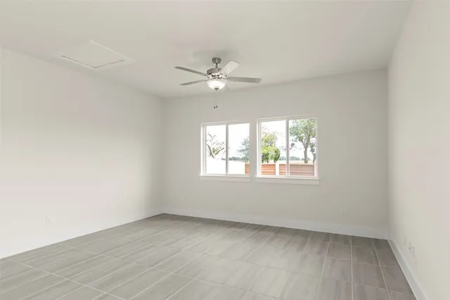 an empty room with a window and ceiling fan