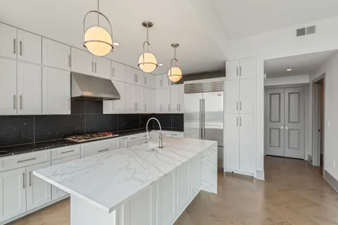a kitchen with granite countertop a sink a counter space appliances and cabinets