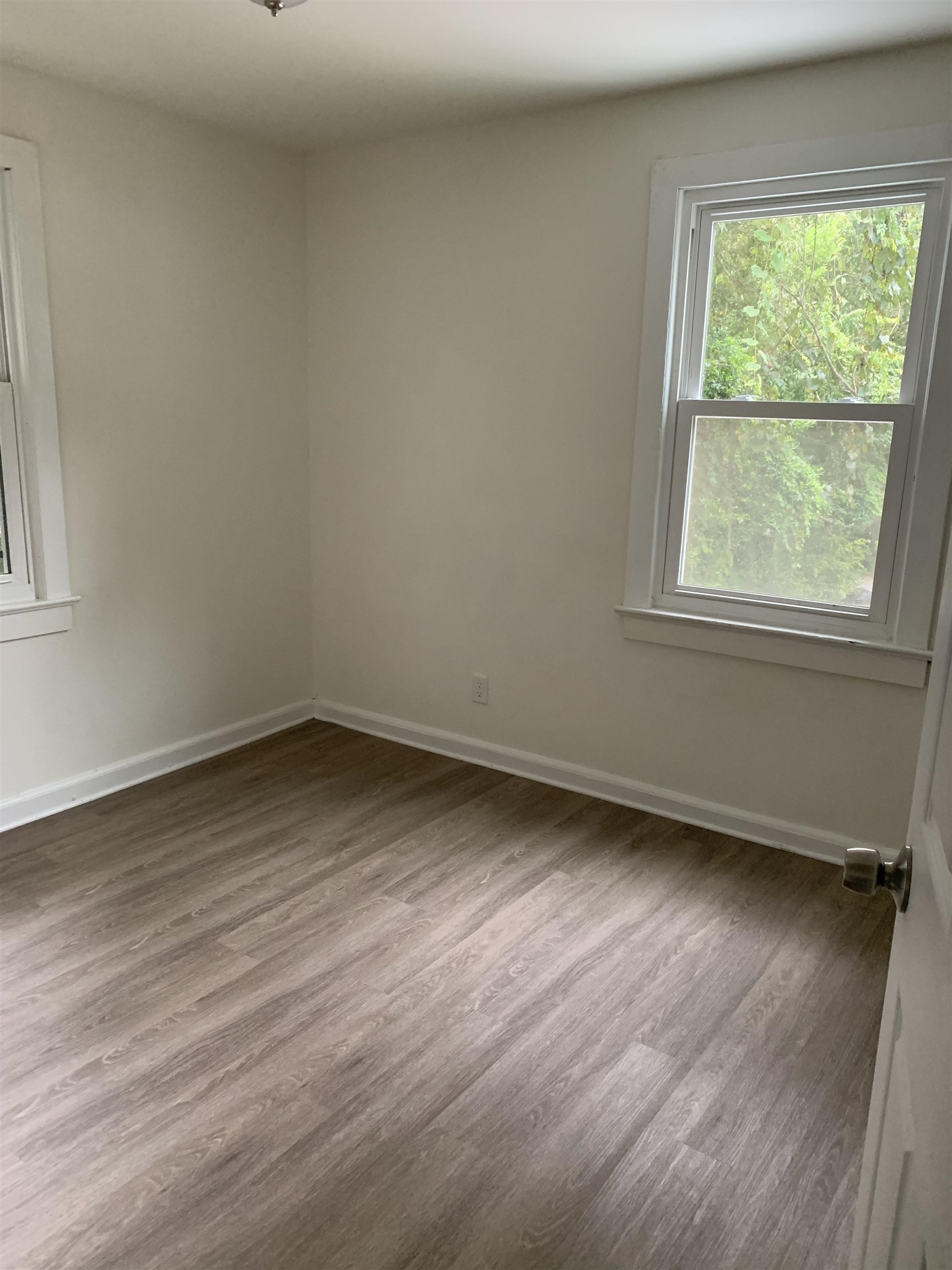 560 Christopher Street, Unit A St. Augustine, FL 32084 - Photo 7 of 8 an empty room with wooden floor and windows
