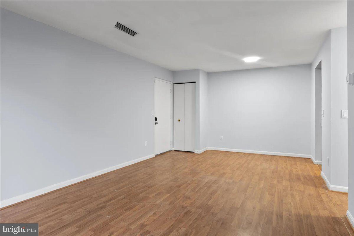 14903 Rydell Road, Unit 104 Centreville, VA 20121 - Photo 5 of 12 a view of empty room with wooden floor and fan
