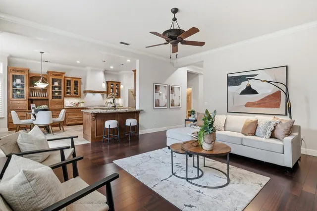 a living room with furniture kitchen view and a chandelier