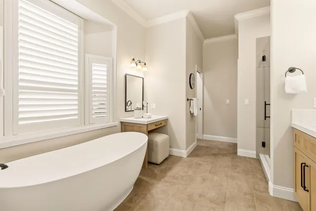 a spacious bathroom with double vanity sinks a large mirror and a shower