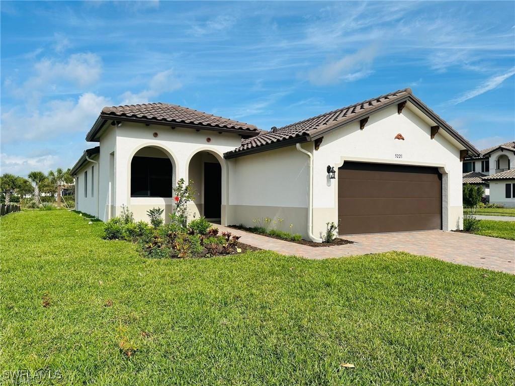 5221 Marano Drive Immokalee, FL 34142 - Photo 1 of 40 a front view of a house with a yard and garage