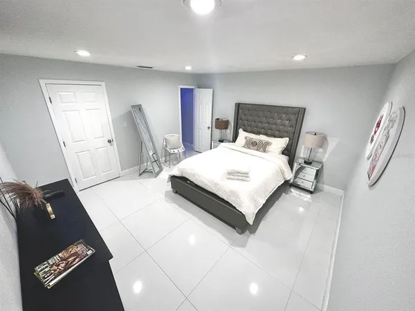 a large bedroom with a bed and wooden floor