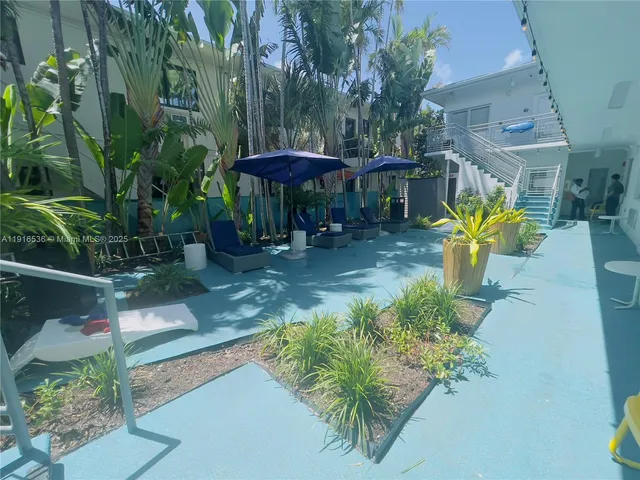 an aerial view of a house with table and chairs under an umbrella