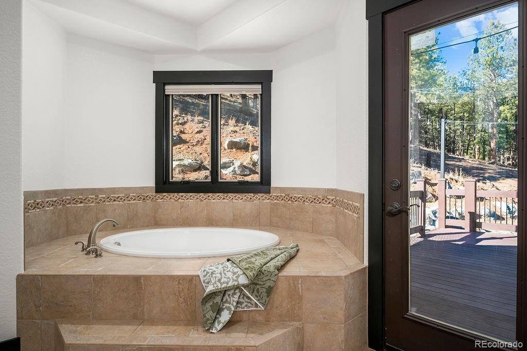 16654 South 7th Street Pine, CO 80470 - Photo 23 of 50 a bath tub sitting in a bathroom next to a window