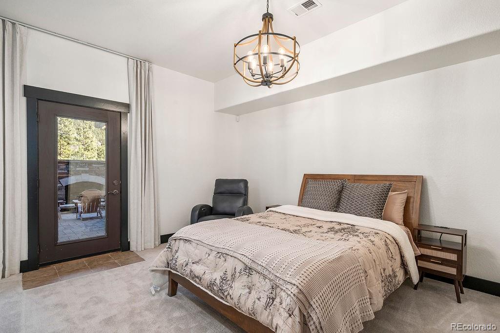 16654 South 7th Street Pine, CO 80470 - Photo 37 of 50 a bedroom with a bed and a chandelier