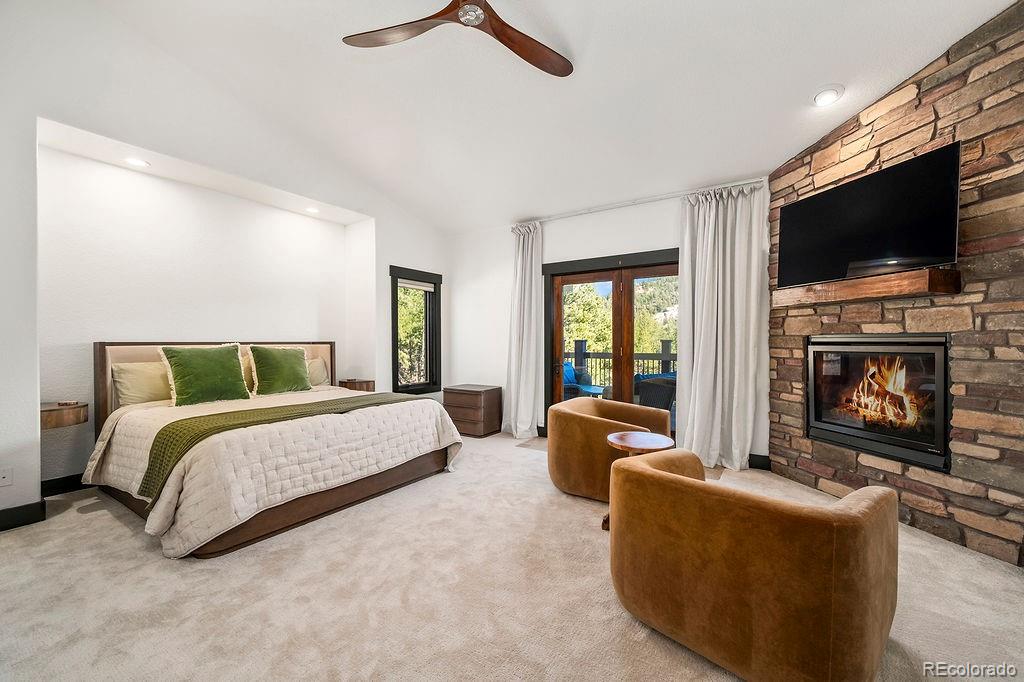 16654 South 7th Street Pine, CO 80470 - Photo 6 of 50 a spacious bedroom with a large bed a flat screen tv and a fireplace