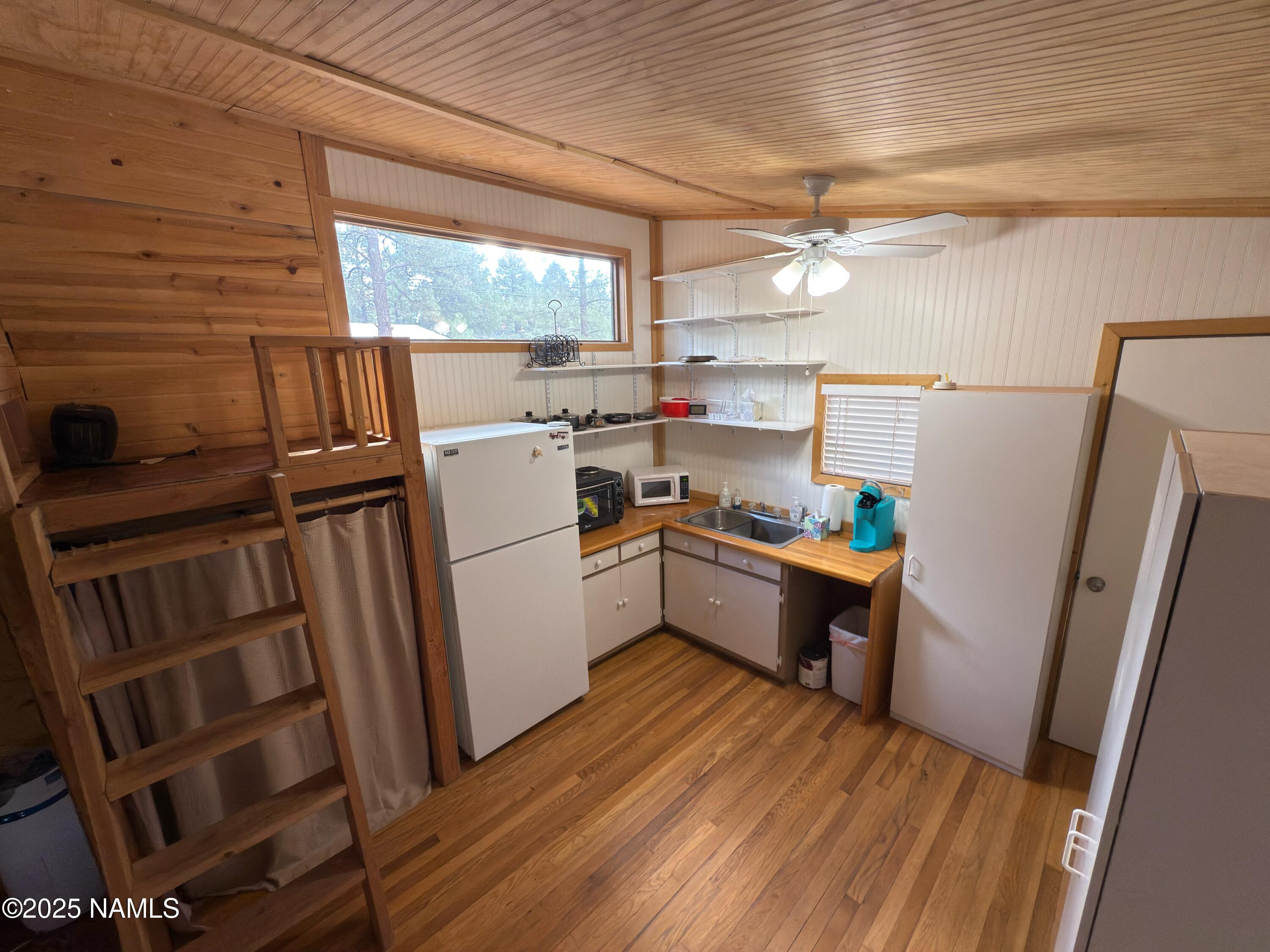 7261 East Long Bow Drive Williams, AZ 86046 - Photo 20 of 43 a kitchen with sink a refrigerator a window and wooden floor