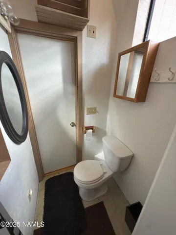 a bathroom with a toilet and a mirror