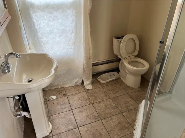 a bathroom with a toilet a sink and a mirror