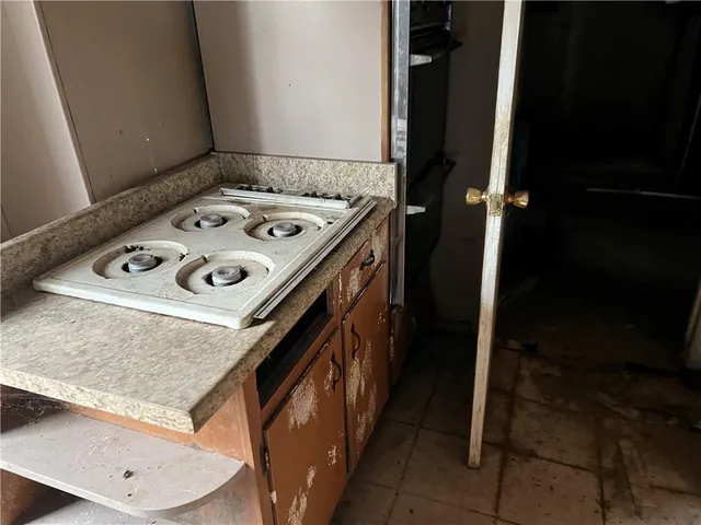 a utility room with stainless steel appliances granite countertop a sink and a stove