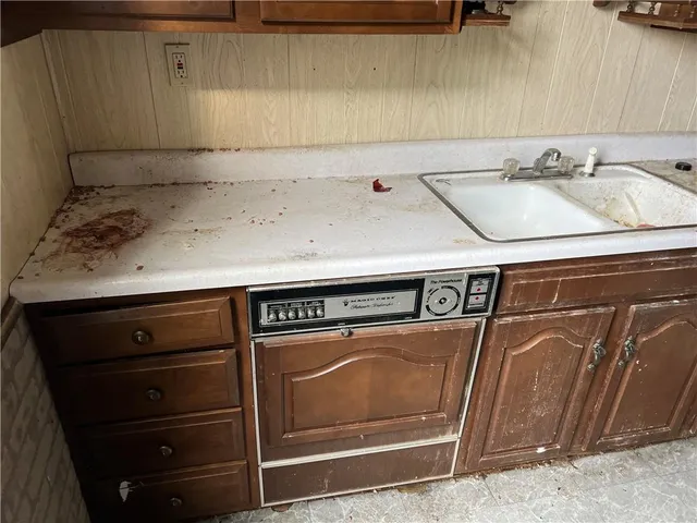 a kitchen with granite countertop a sink stove and cabinets