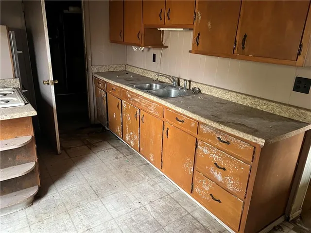 a kitchen with granite countertop a sink a stove and cabinets
